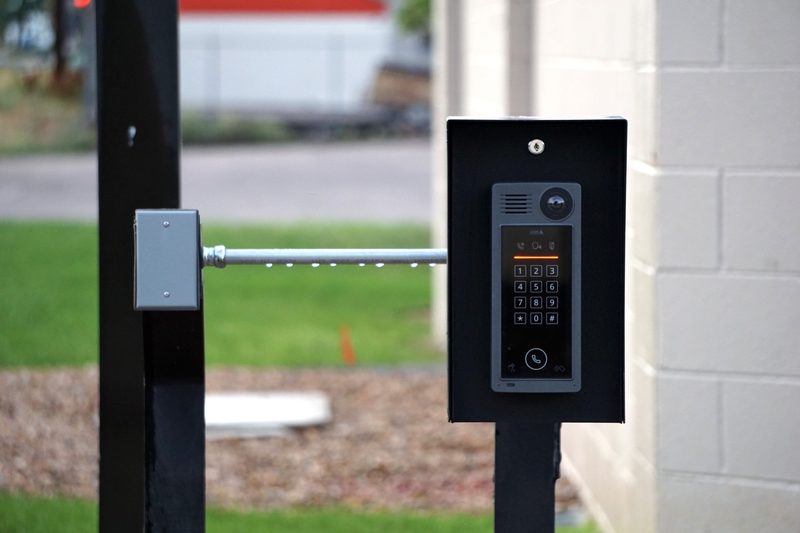 Keypad and video intercom in a steel housing on a post at a gate entrance